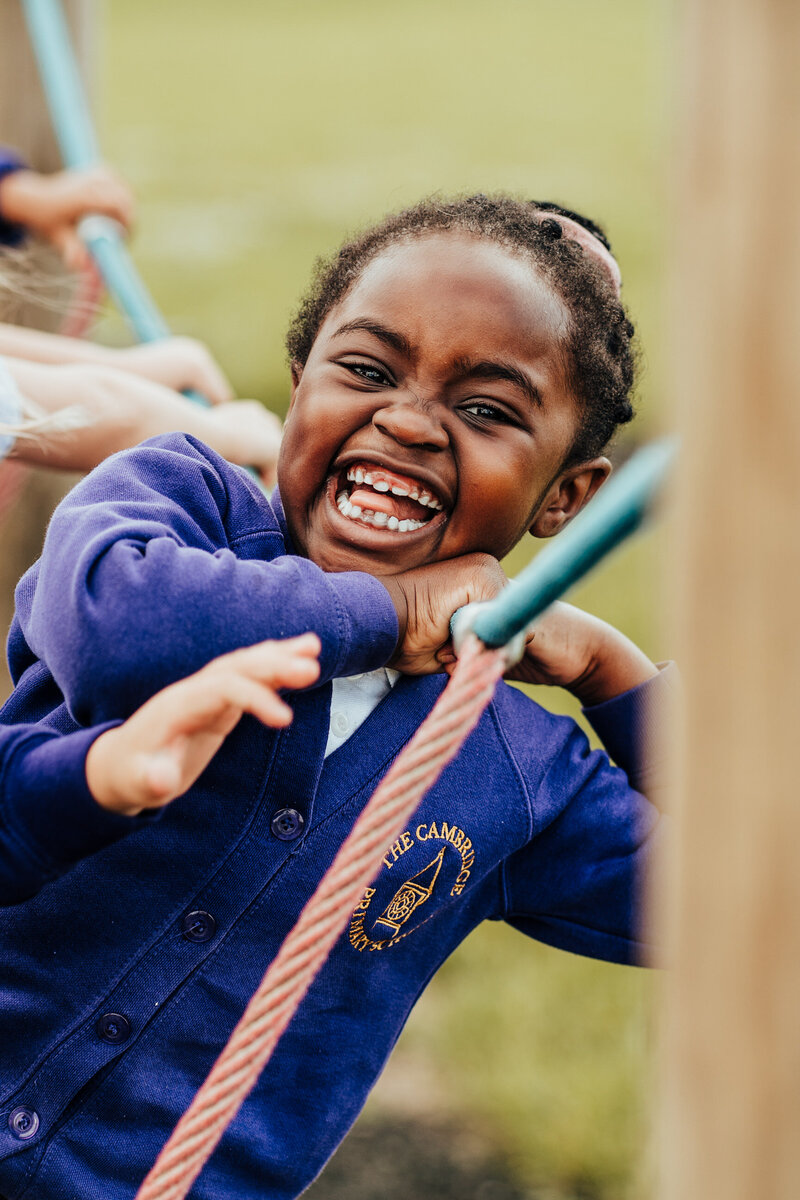 Girl smiling on playground at The Cambridge Primary School