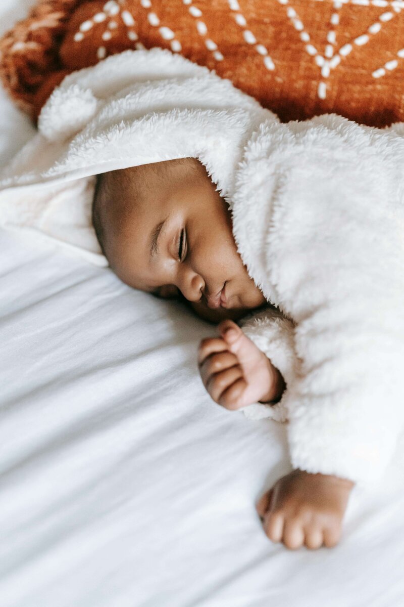 Newborn asleep on a bed