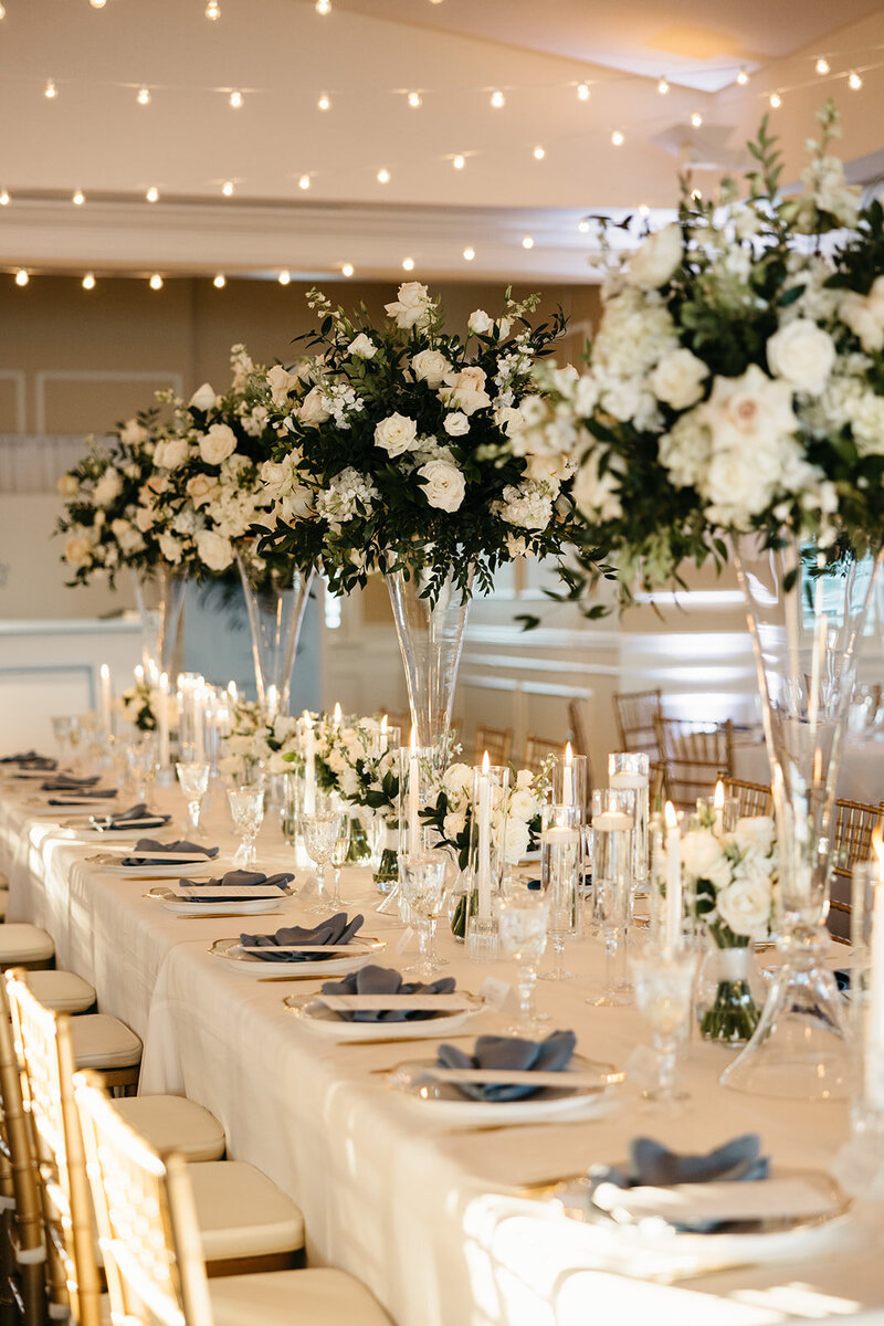 Elegant black and white wedding reception detail with floating candles and white roses, highlighting refined wedding design by The Eventful Gals.