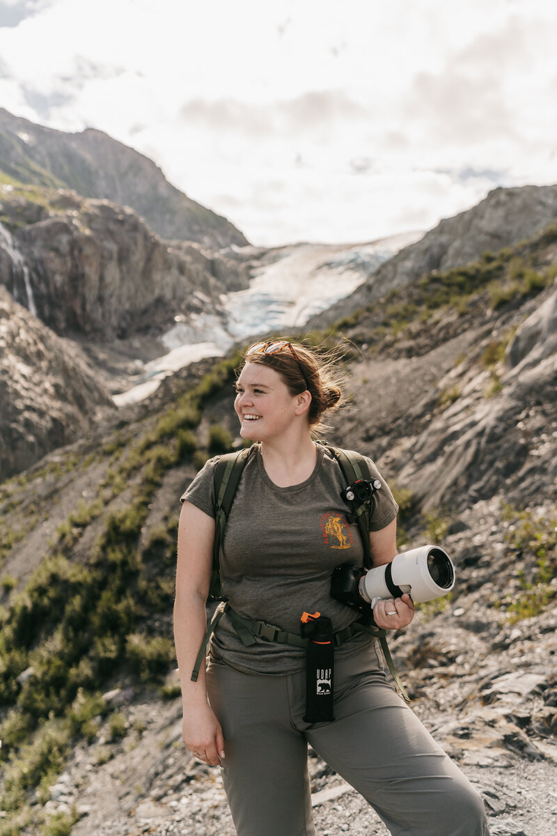 Montana Wedding Photographer stands in front of a glacier in Seward, Alaska.