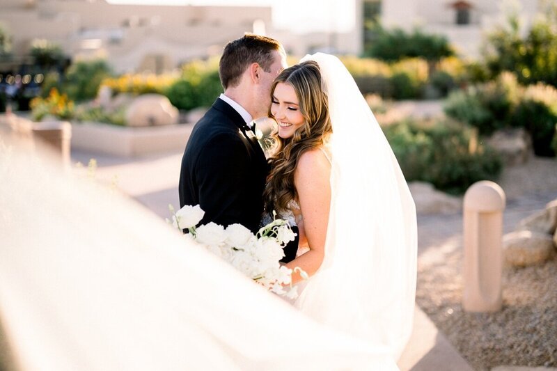 Intimate bride and groom embrace with desert backdrop - Scottsdale wedding photographer.