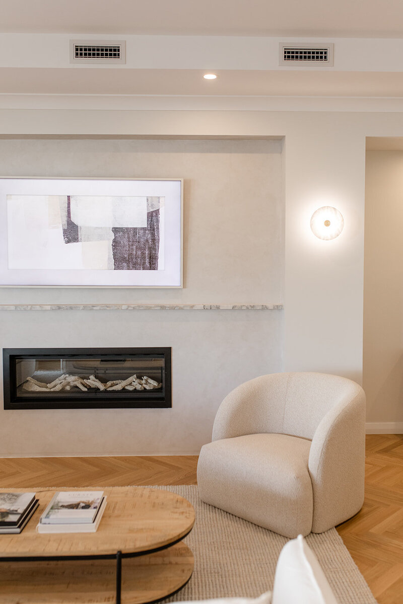 Fireplace with white lounge chair in front