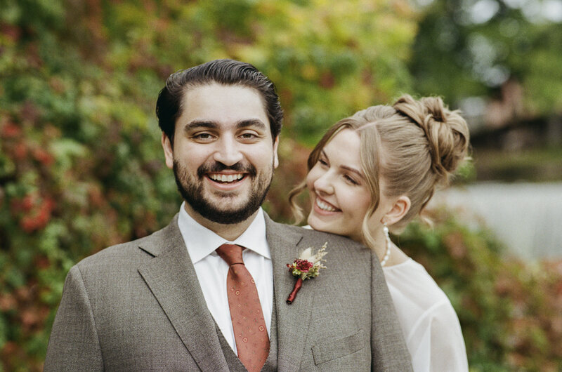 Fun and candid portrait of bride sneaking up on groom at The Roundhouse in Beacon shot on 35mm film