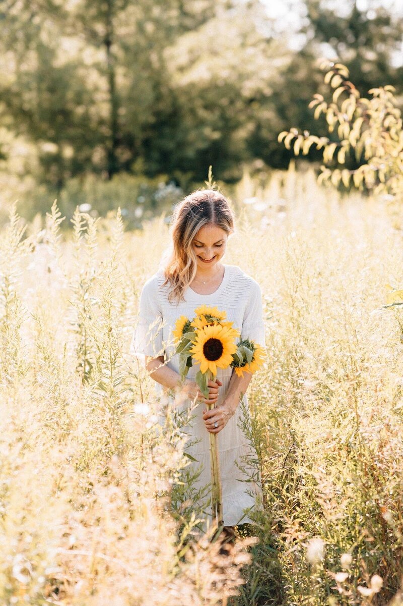 Dana Readings, spiritual coach, with sunflowers in a field