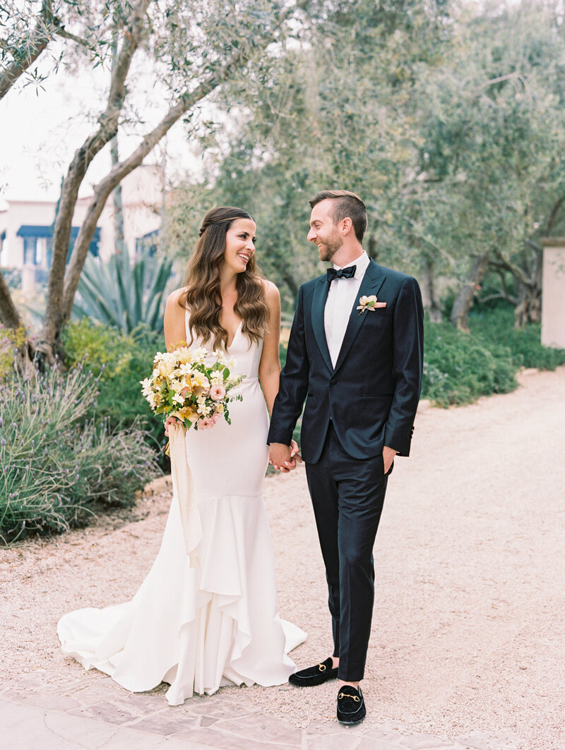 Groom embraces his smiling bride on their wedding day at Klentner Ranch in Montecito