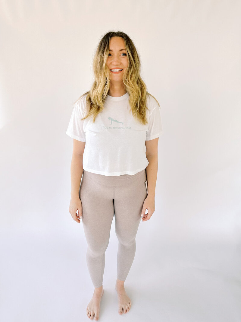 Woman wearing a white cropped True40 tee with logo icon