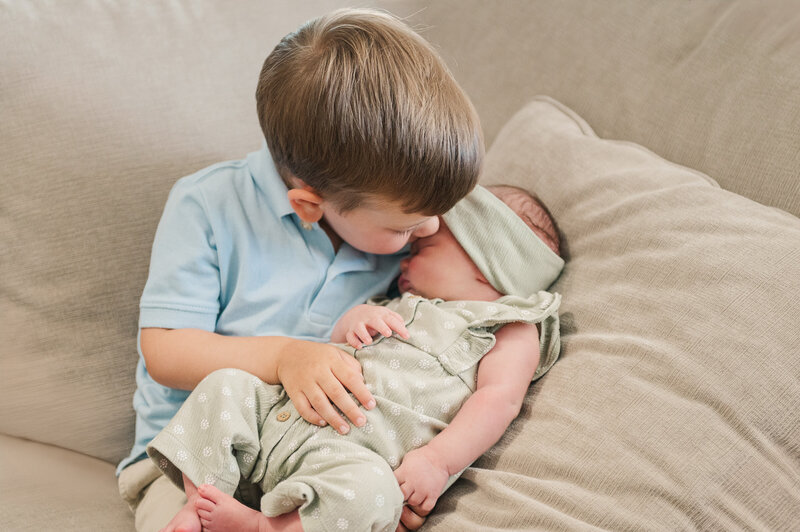 brother kissing sister in home lifestyle session by newborn photography baltimore md