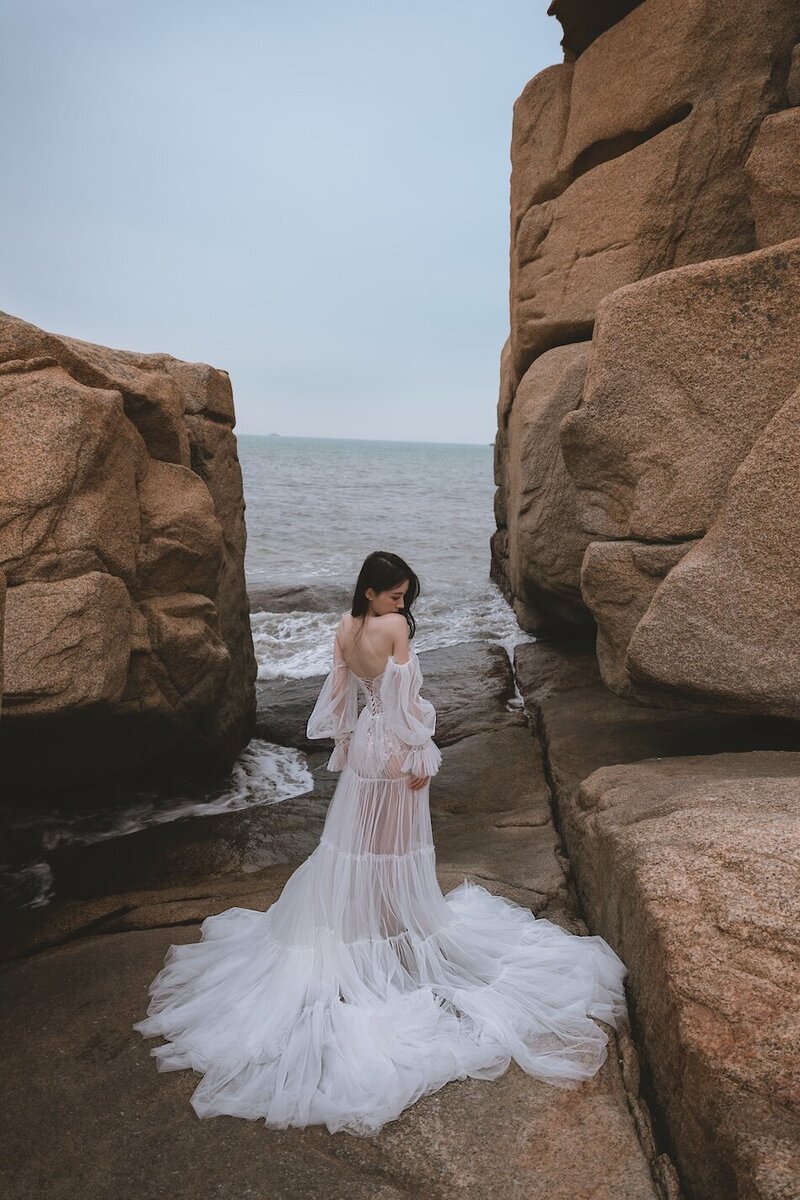 A beautiful windswept beach couture shoot amongst coastal rocks.
