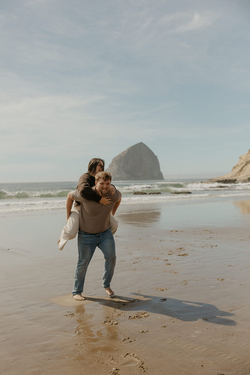 A couple laughing as one holds the other on their back 