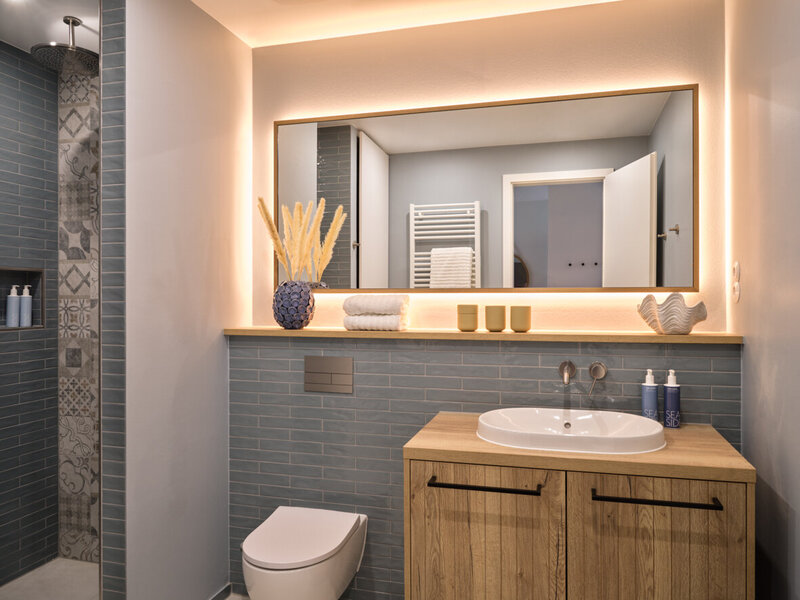 Badezimmer mit Waschbecken, WC und Dusche im Couple Liiving Apartment.