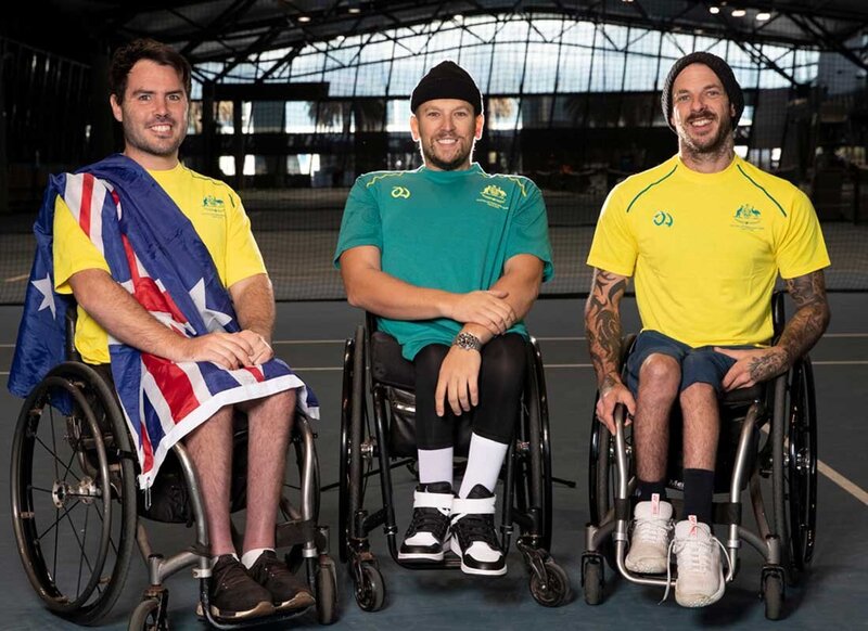 Three Australian wheelchair tennis athletes pose proudly on court for Paralympic team portrait