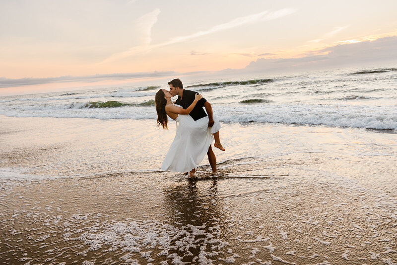 A couple dips on a beach in virginia during their elopement