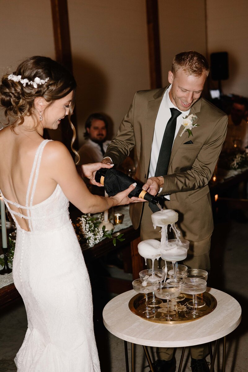 A just married couple pours a champagne tower together after their Toledo, Ohio wedding