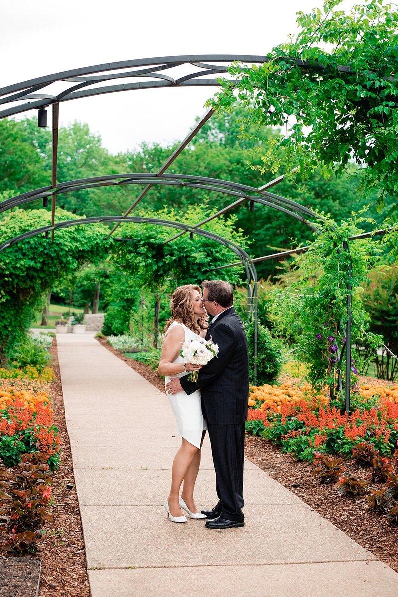 Bright flowers surrounding couple who are whispering to on another during their Cheekwood photoshoot