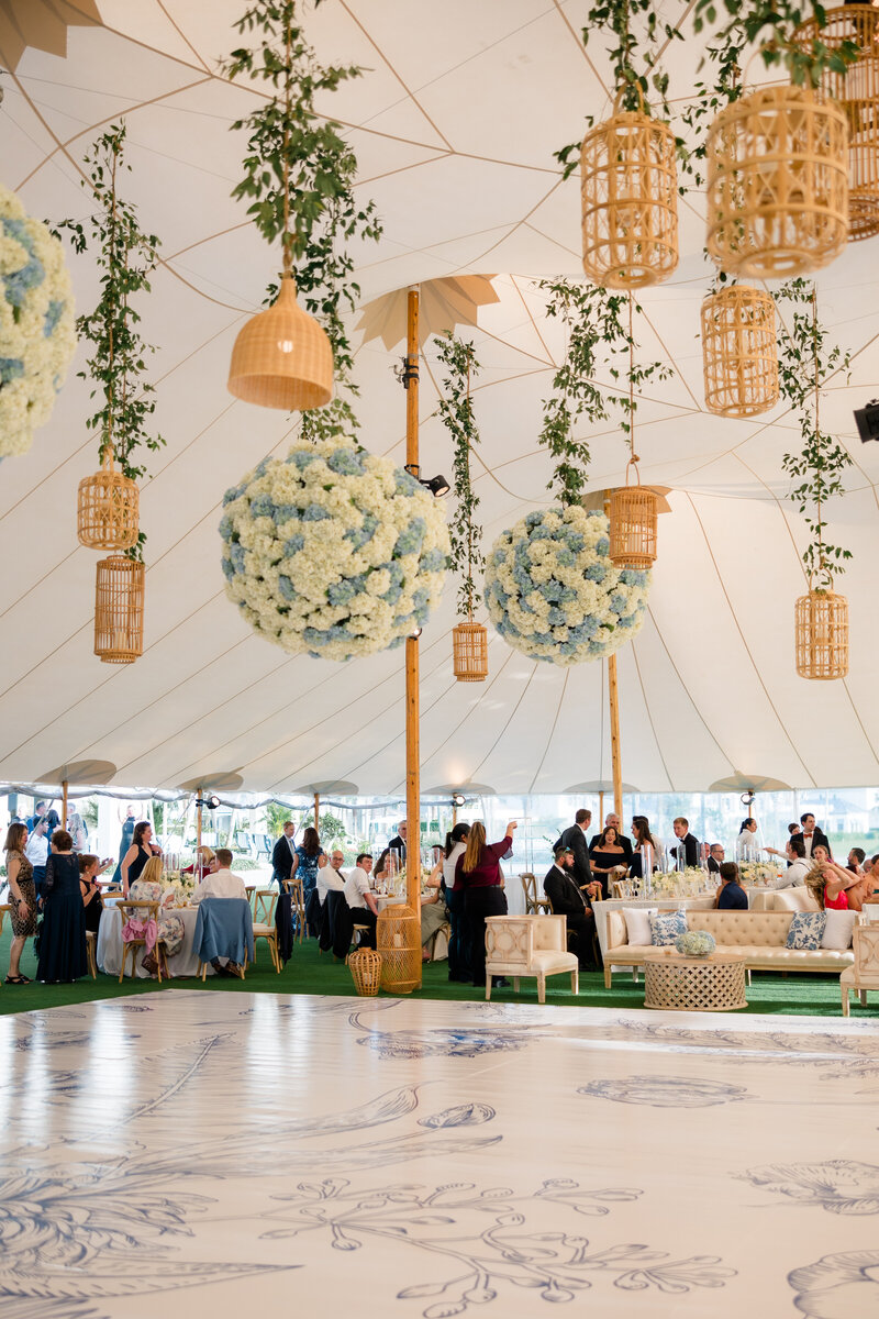Sperry tent filled with guests for wedding reception custom floor wrap and hydrangeas floral decor