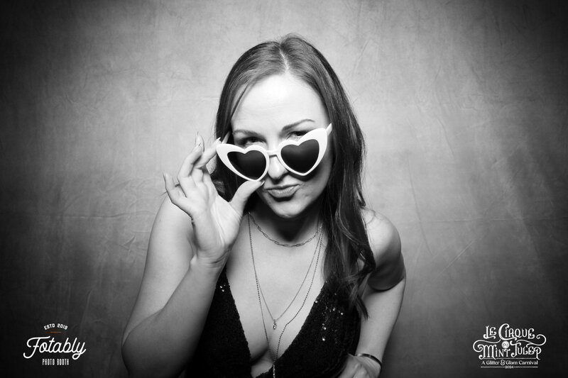 A black and white image of attractive brunette posing in a moody houston photo booth