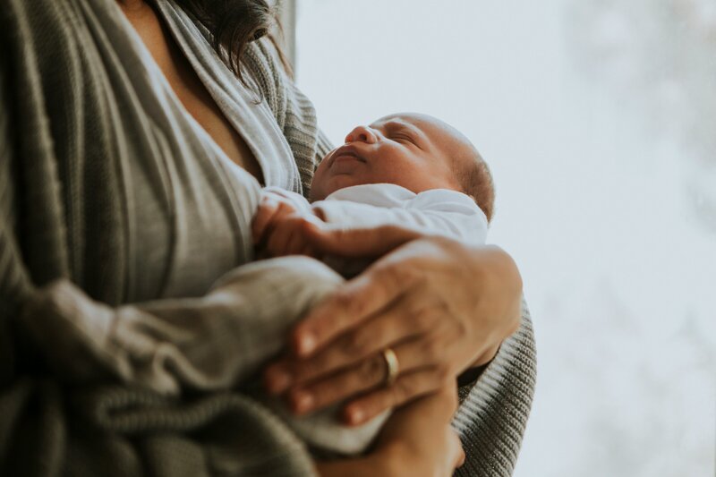 A woman holding her newborn baby.