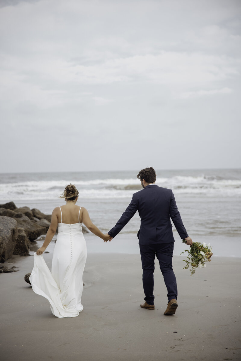 destination wedding photographer captures the bride and groom candidly walking on the beach