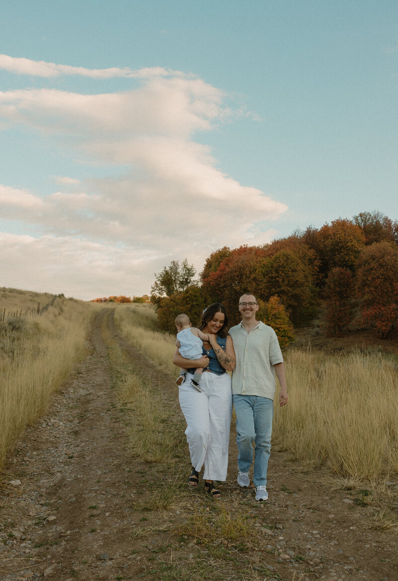 Couple sitting on the ground outside in a maternity shoot in Idaho Falls, ID.