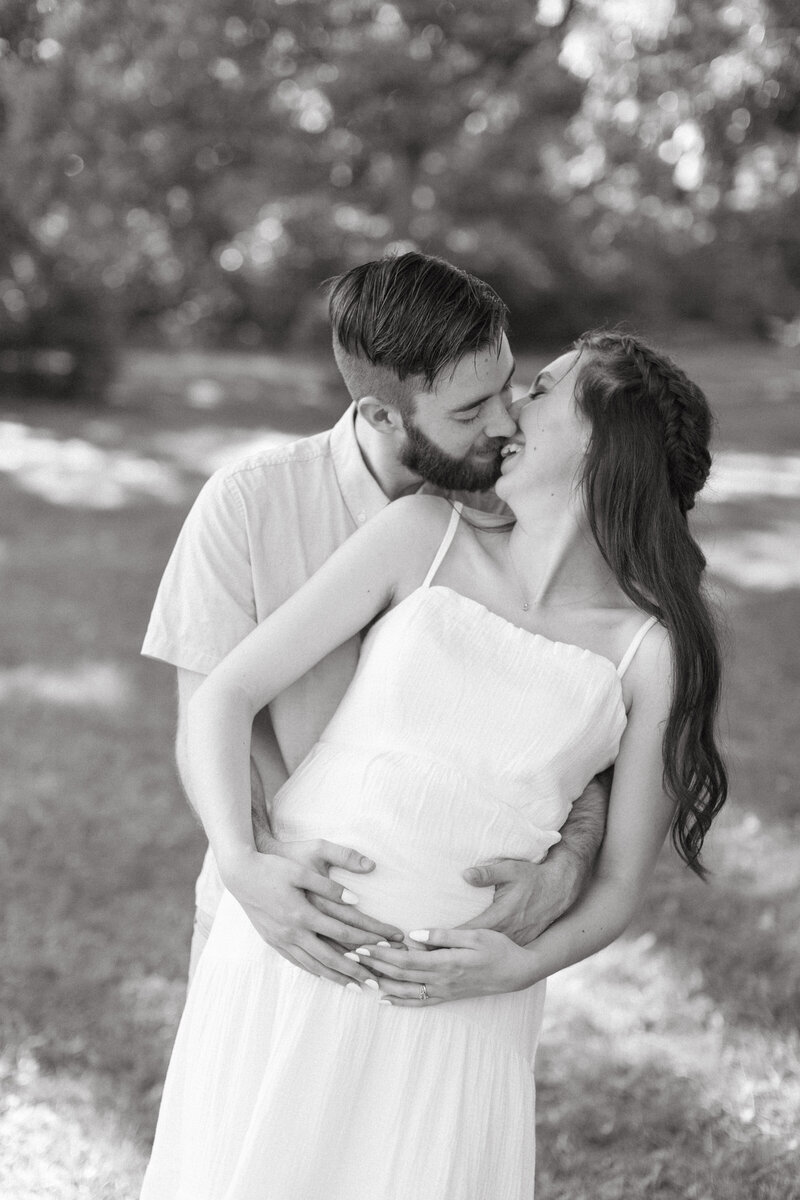 black and white pregnant couple kissing