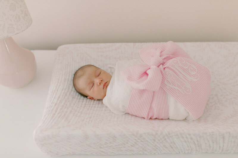 Newborn girl swaddled in crib during lifestyle session in Richmond, Virginia.