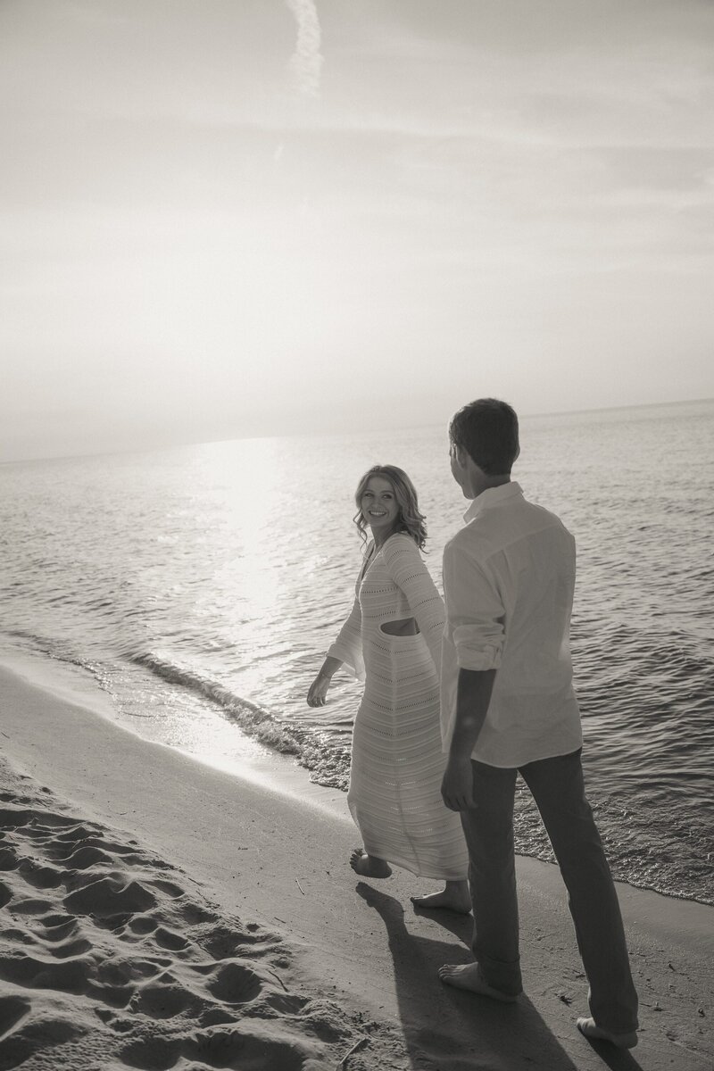 black and white photo of couples holding hands walking on the beach of Lake Michigan