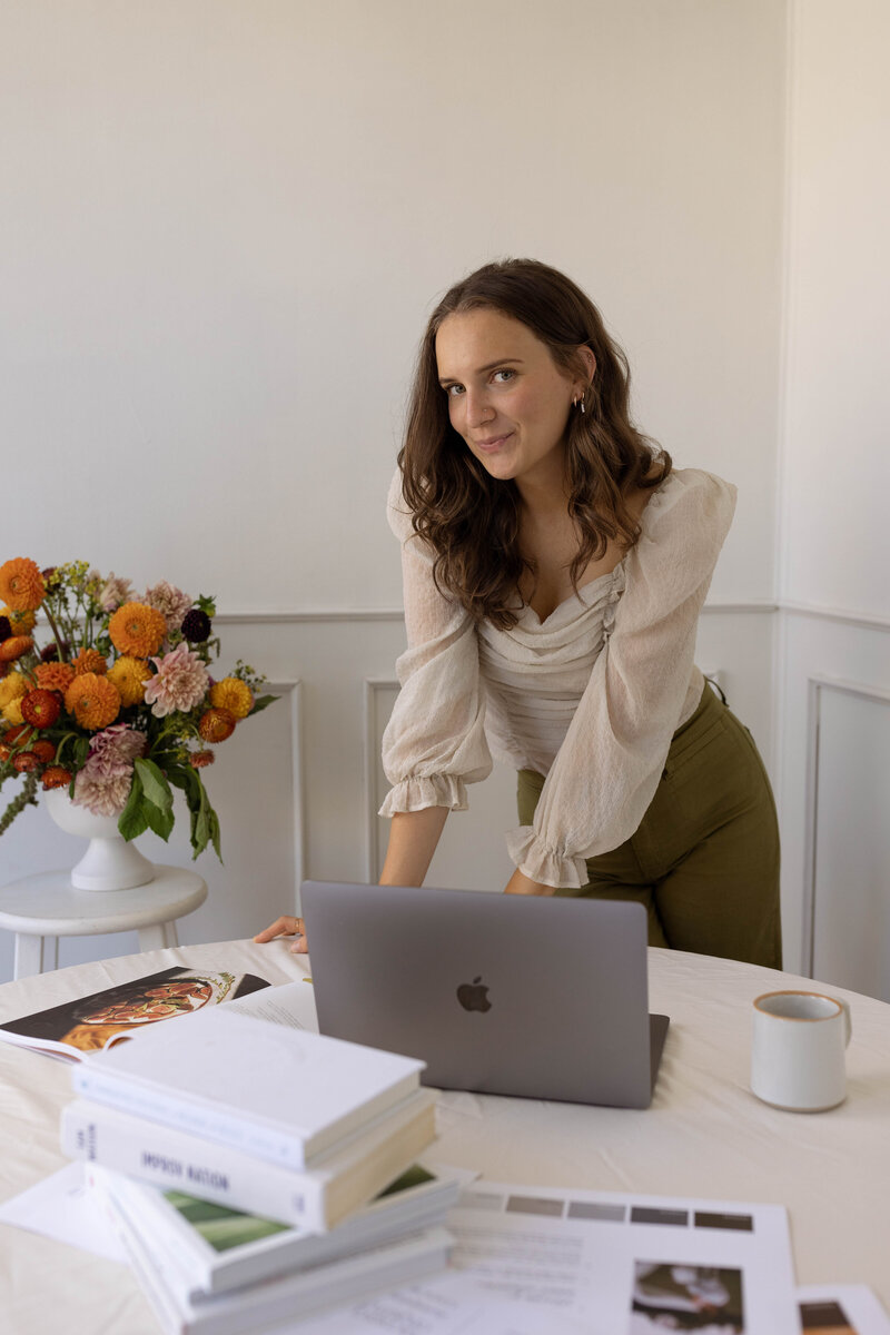 A woman working on freelance website design on her computer.
