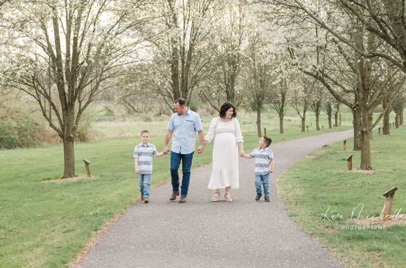 family walking together during maternity session by photographer baltimore md