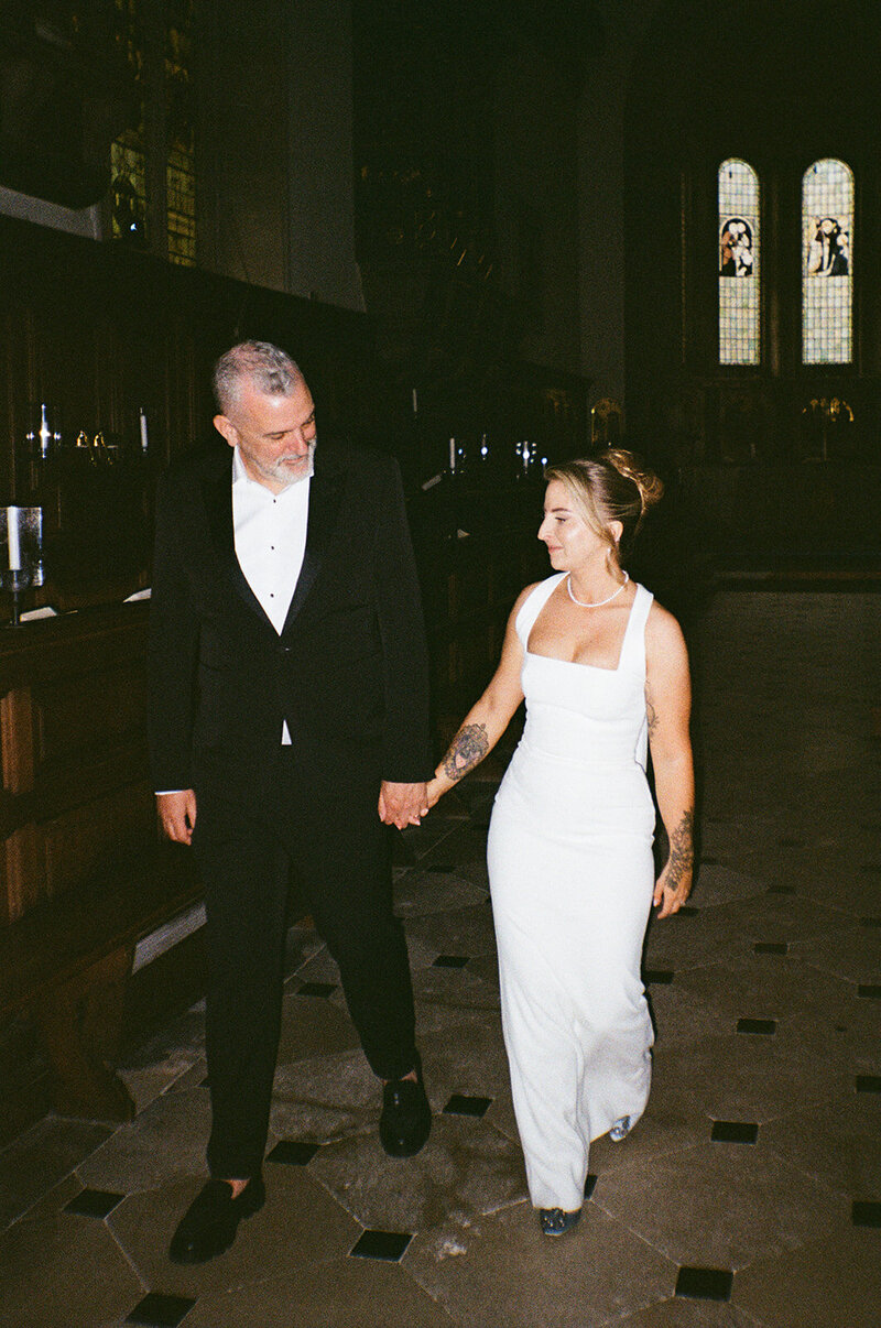 Portrait of a couple walking through a chapel shot with direct flash on 35mm film