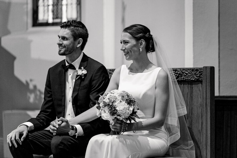Bride and groom sitting down during their ceremony at their church