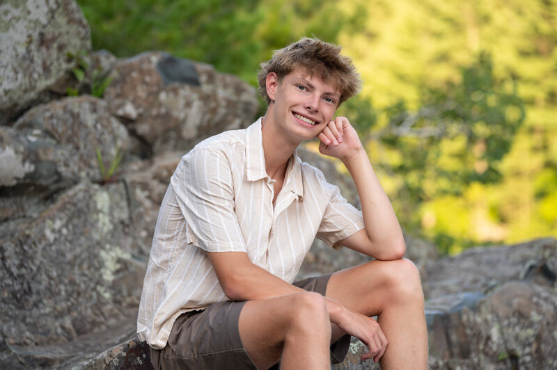 high school boy smiles for his senior portrait
