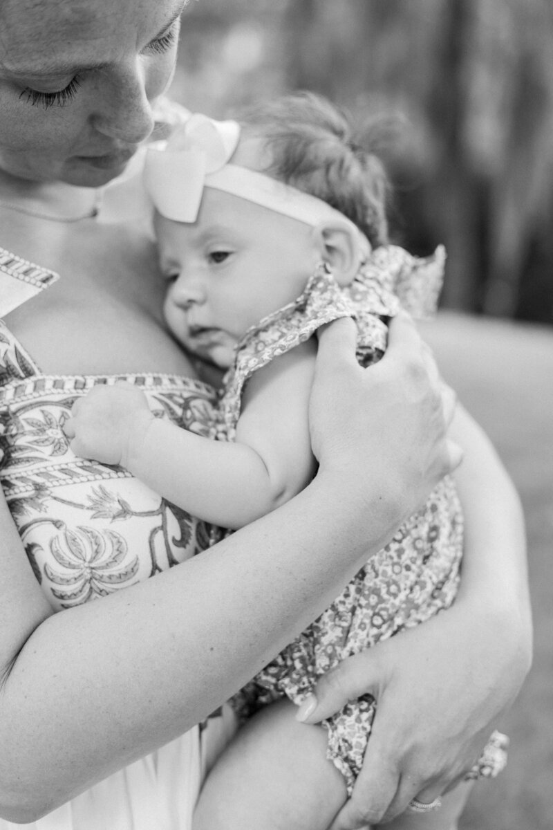 Mom cradling baby girl for family portrait session with Palmetto Bluff Photographer Lamp and Light Photography.