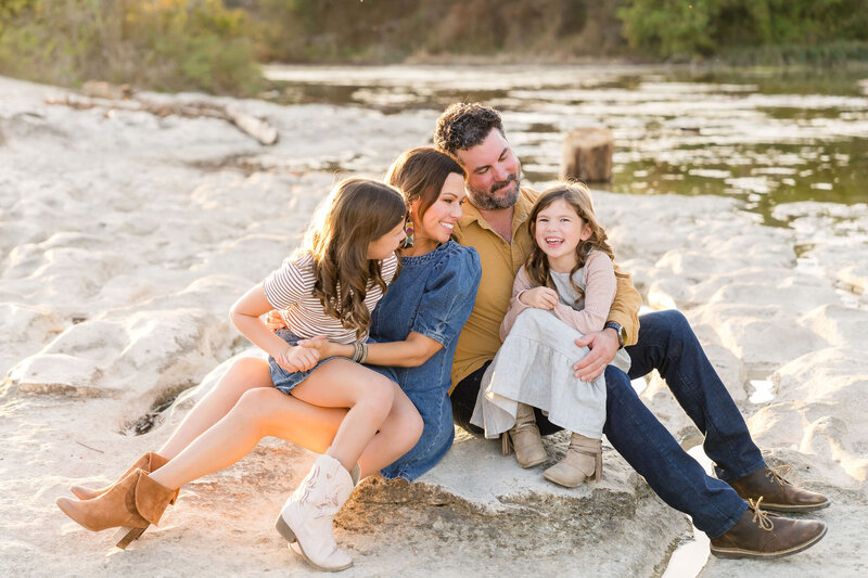 A family laughs together at McKinney Falls State Park in Austin, Texas during their lifestyle family photos.