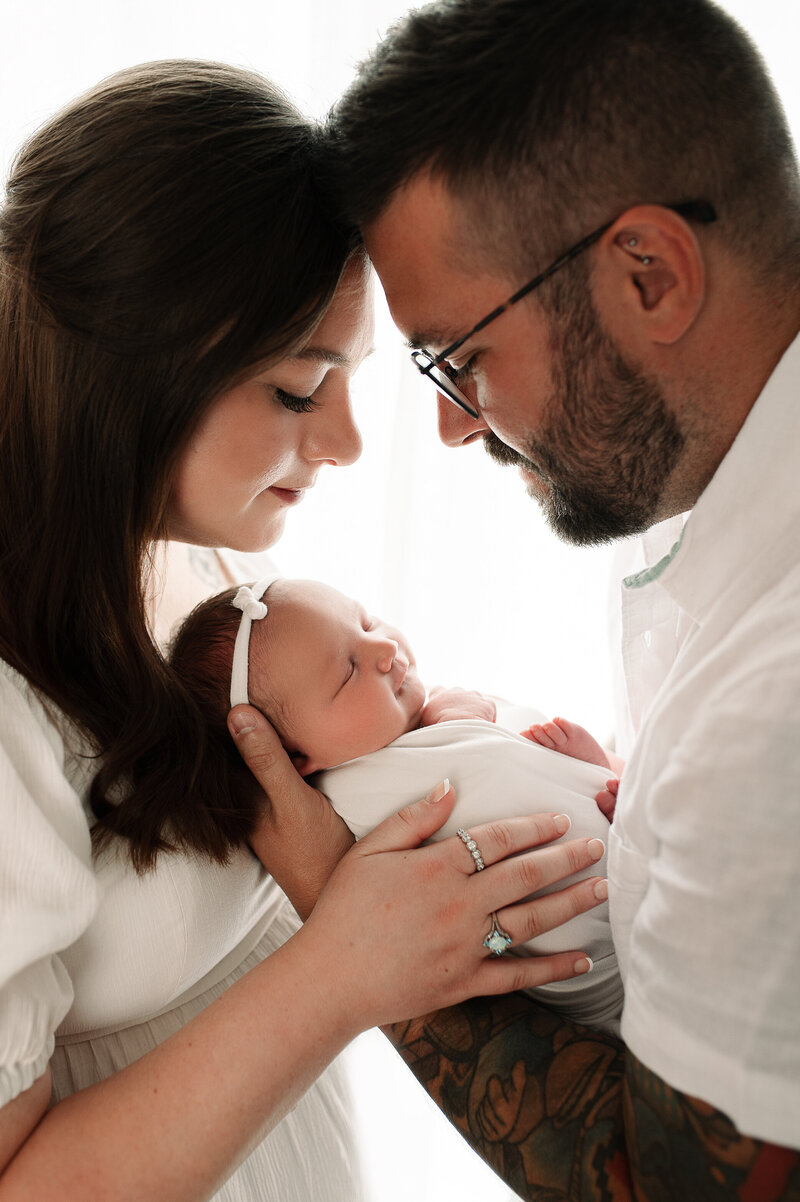Mother and Father holding newborn in studio natural light Swanton, ohio
