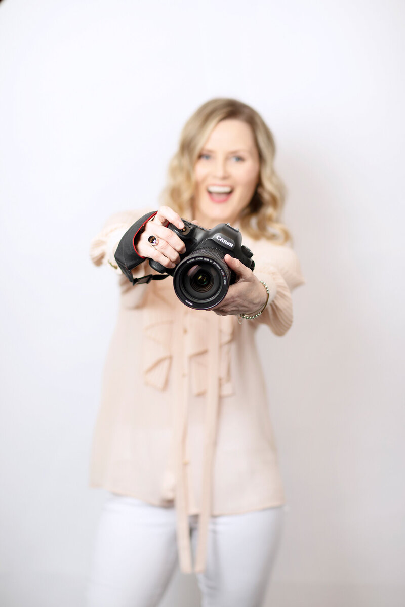 photographer holding a camera with out stretched arms