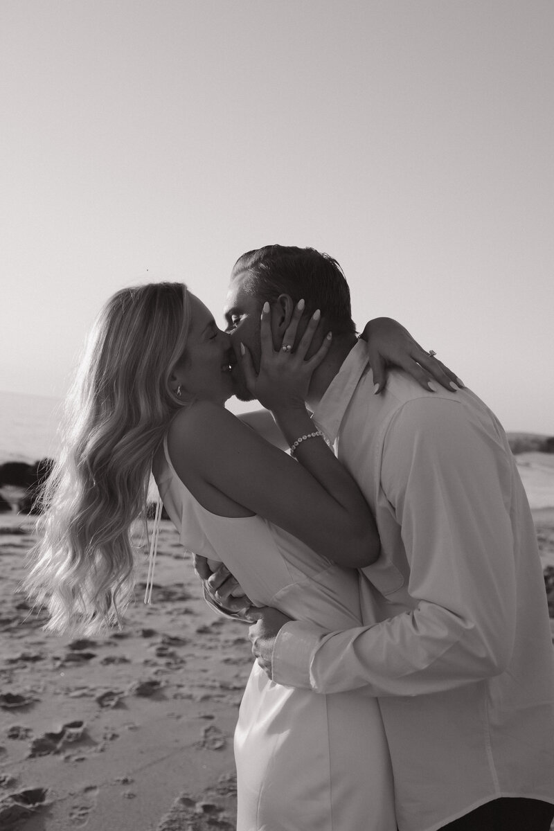 bride and groom hugging and laughing on california beach