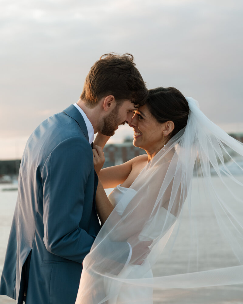 Bride and groom kissing at sunset during Newport wedding
