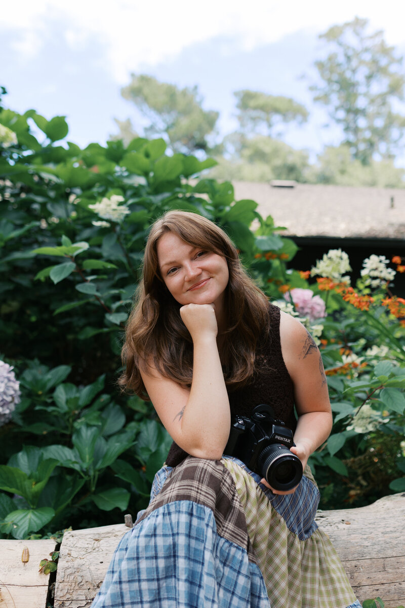 Woman holding a super 8 video camera in a field in Colorado.