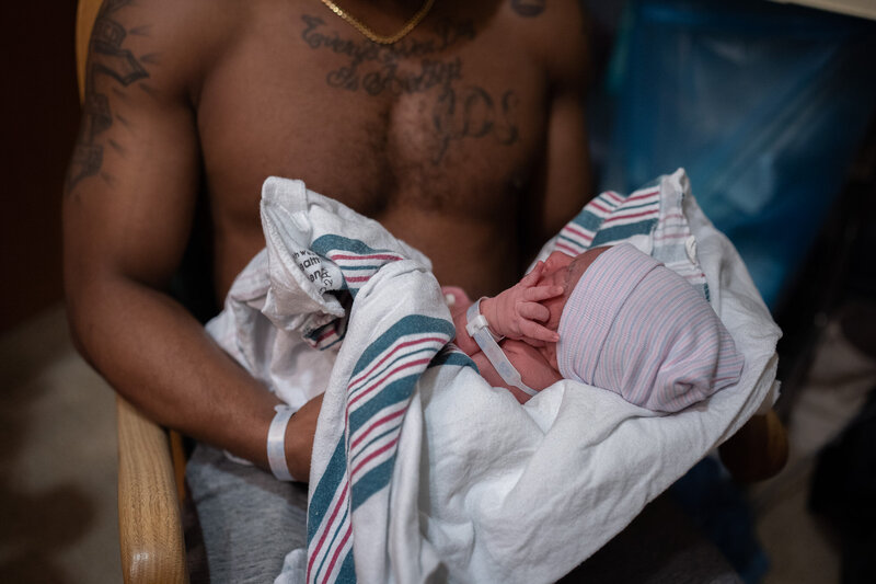 a new dad holds his new infant at Evergreen hospital captured by Seattle Birth Photographer, Becky Langseth.