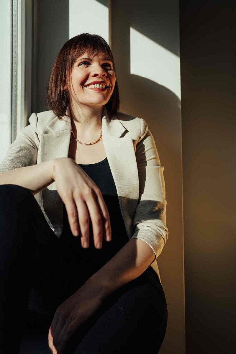 Professionelles Portrait der Fotografin, natürliche Haltung und sympathisches Lächeln