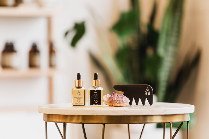 Hui Hui hair products including two dropper bottles and a black comb displayed on a round table representing cruelty free hair products.