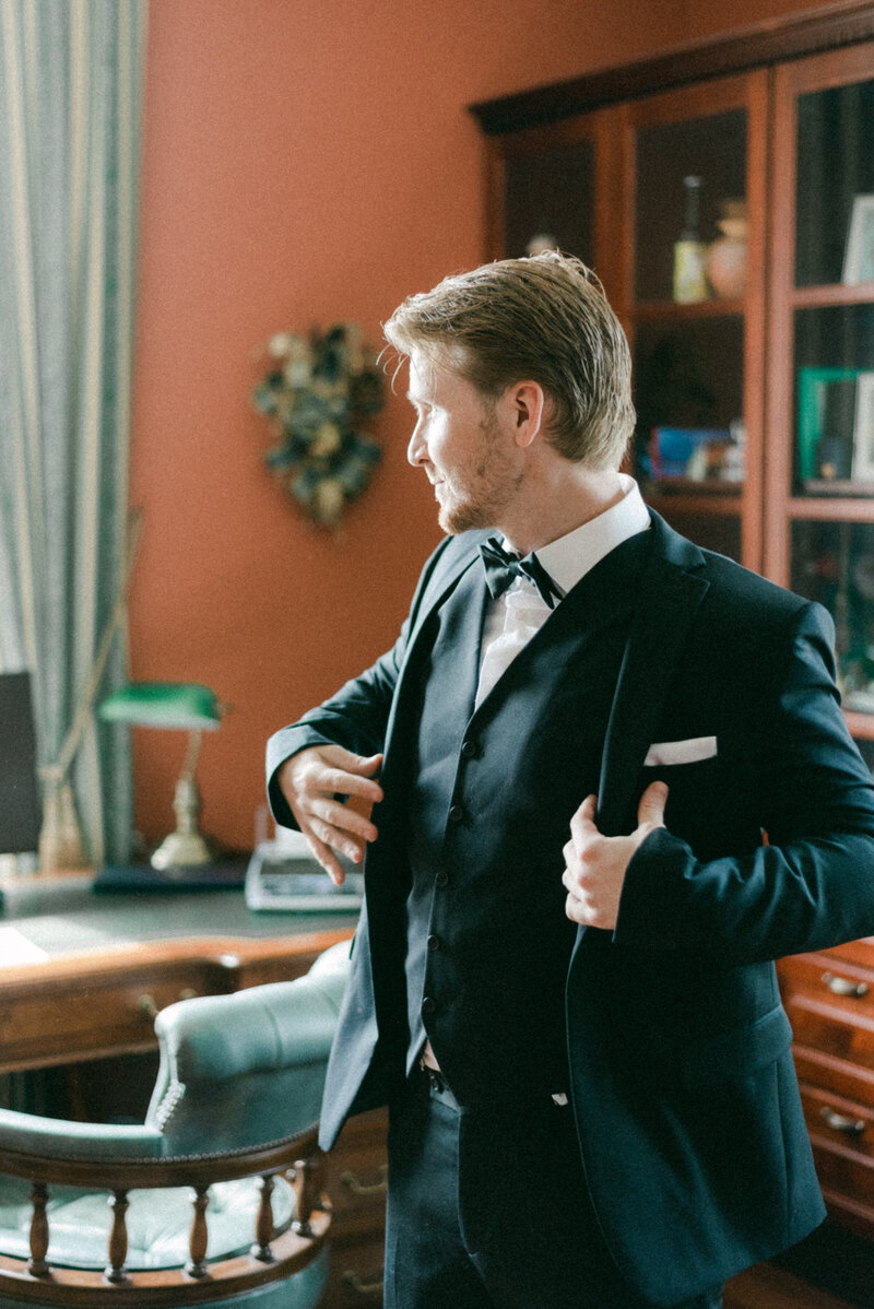The groom is puttin on the suit in an image captured by wedding photographer Hannika Gabrielsson.