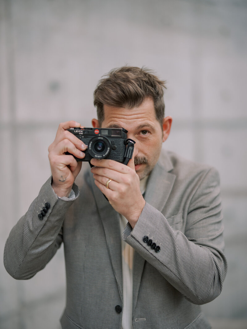 Photographer in suit captures a shot with a classic camera