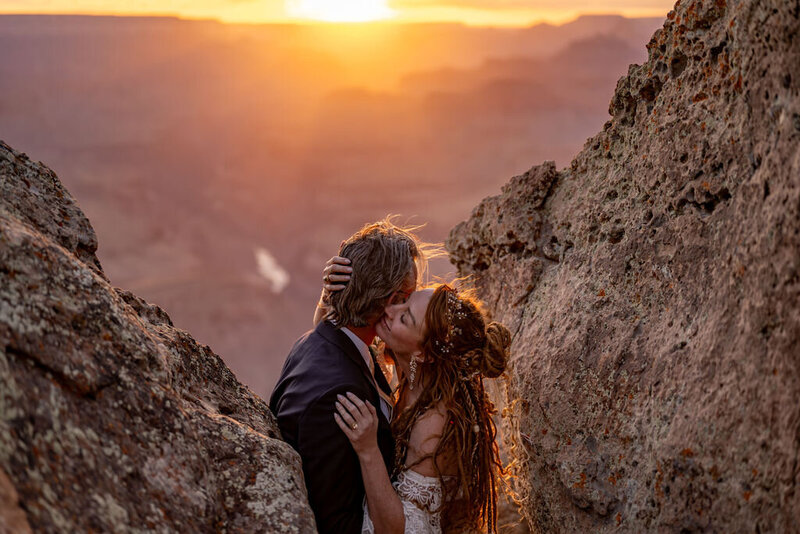 Bride and groom posing for romantic wedding portraits against the dramatic Grand Canyon landscape.