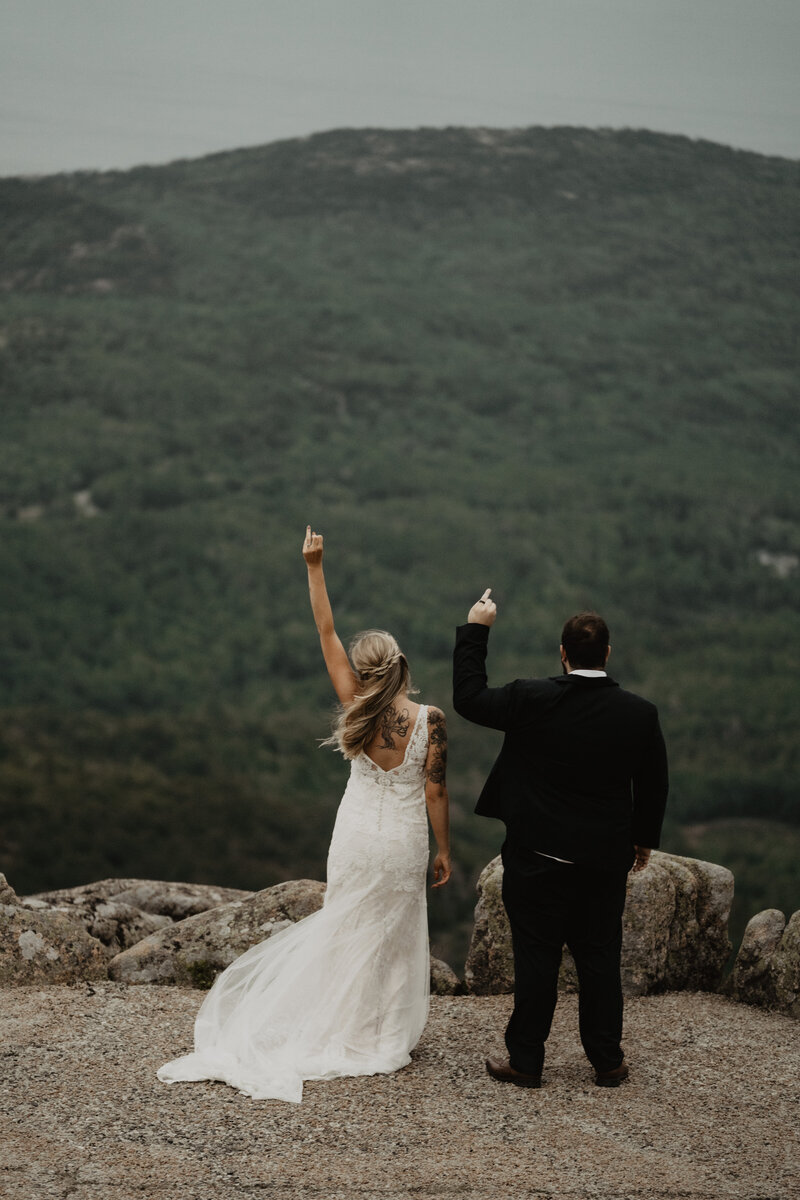 bride and groom holding up rings