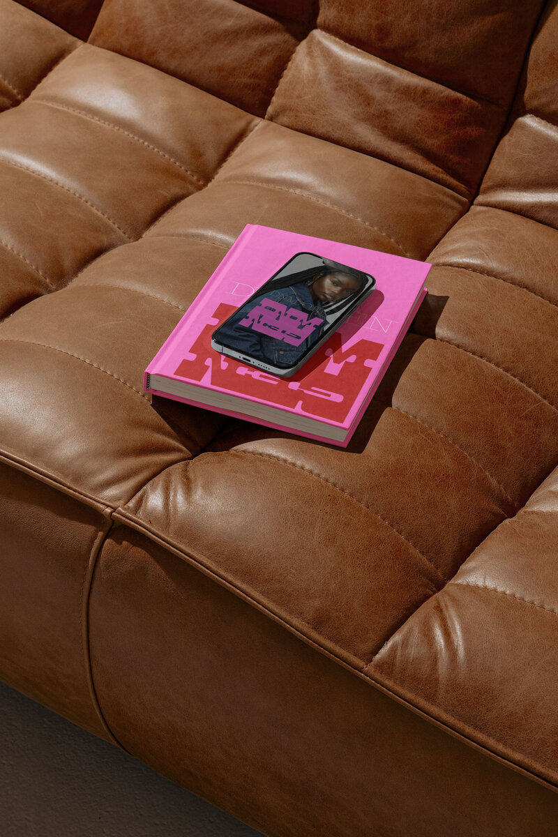 iphone and book showcasing dnm gen on a brown leather couch