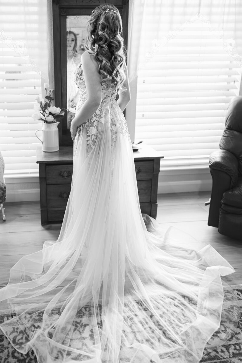 A bride's dress blows in the wind in Texas as her groom holds her.