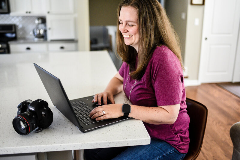 Danielle Hardesty looking down at laptop smiling