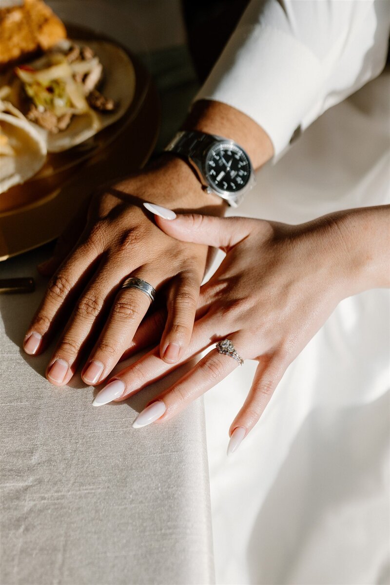 Two hands of bride and groom showing their wedding rings