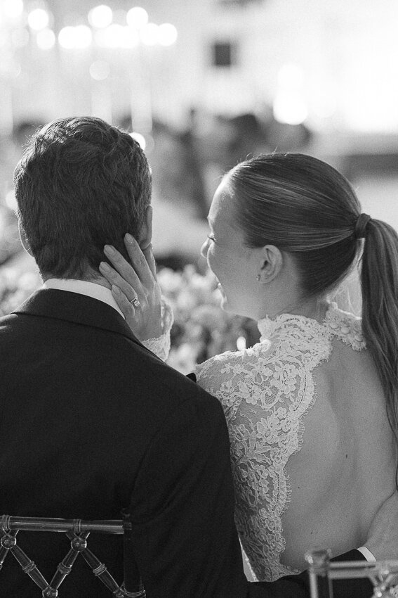 Un couple de nouveaux mariés assis à la table d'honneur lors de la réception de mariage. Moment naturel.